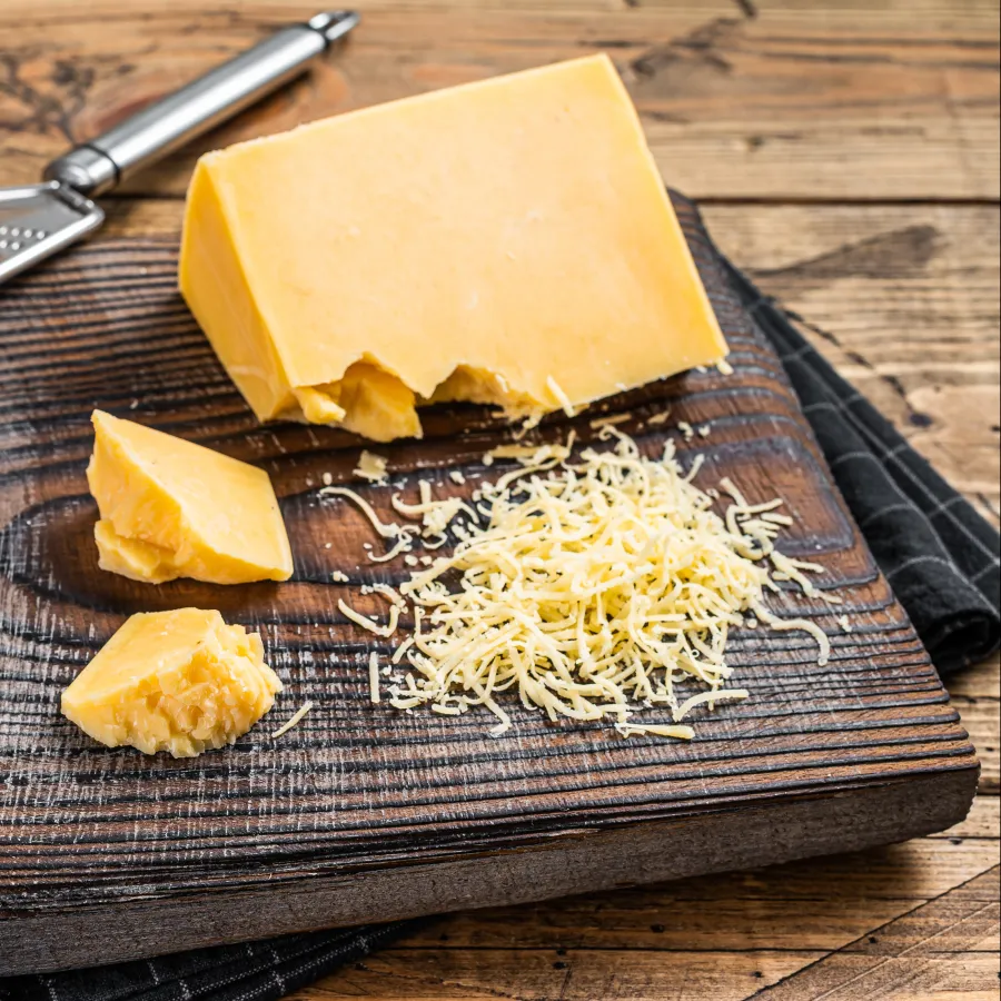 Morceau de cheddar sur une planche en bois 